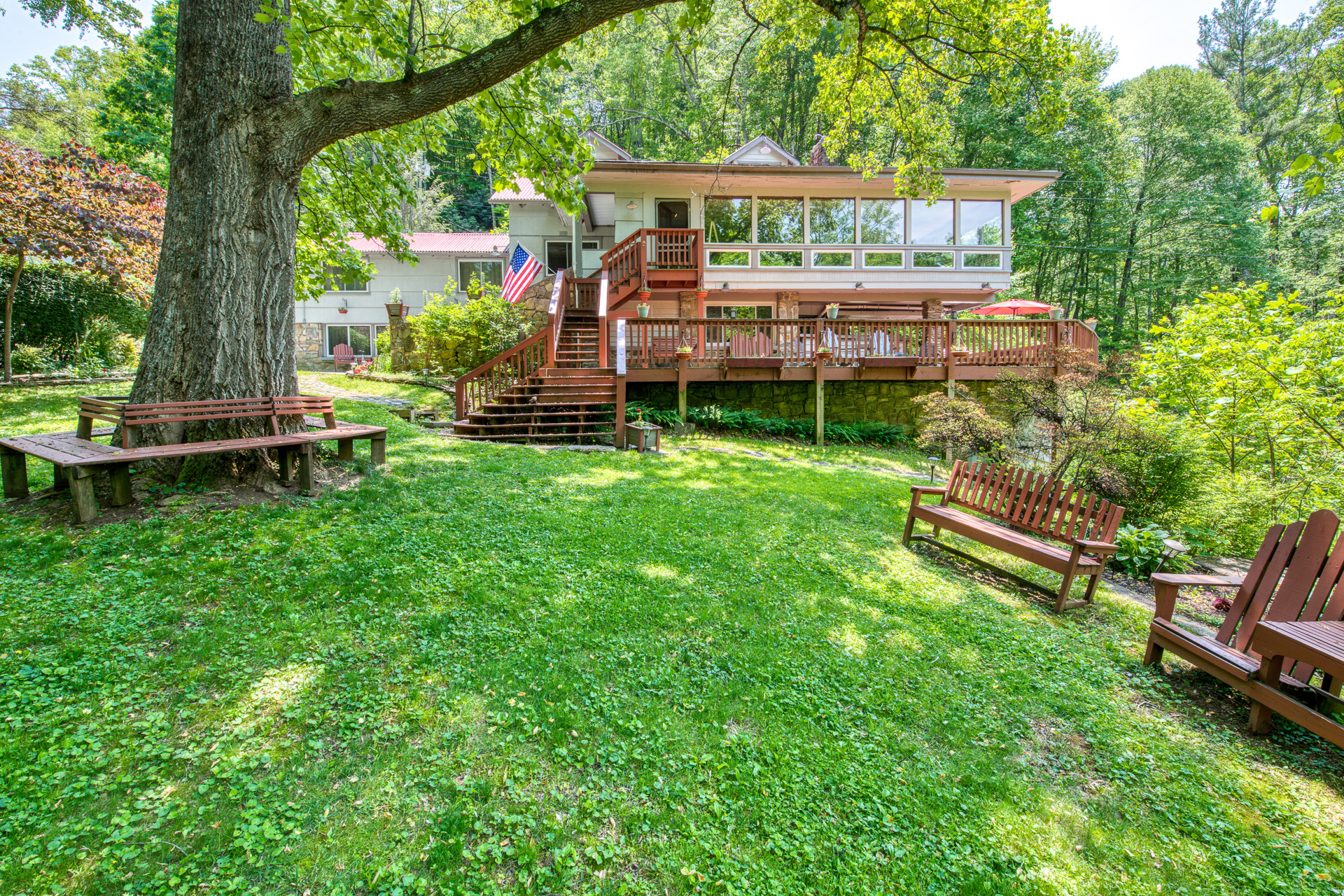 Red Leaf River Inn in Waynesville, NC featuring a lush green lawn and shady trees.